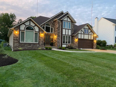 Front view of a home with newly mulched flowerbeds and stripe mowed lawn by Chestnut Landscaping