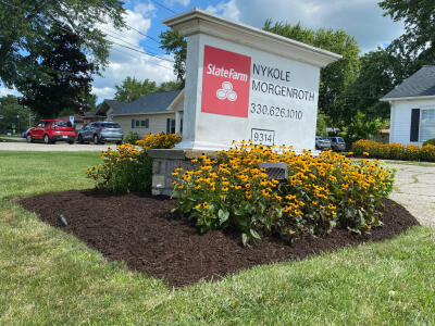 A cleaned up flower bed with blooming flowers in front of a commercial property in Aurora Ohio maintained by Chestnut Landscaping